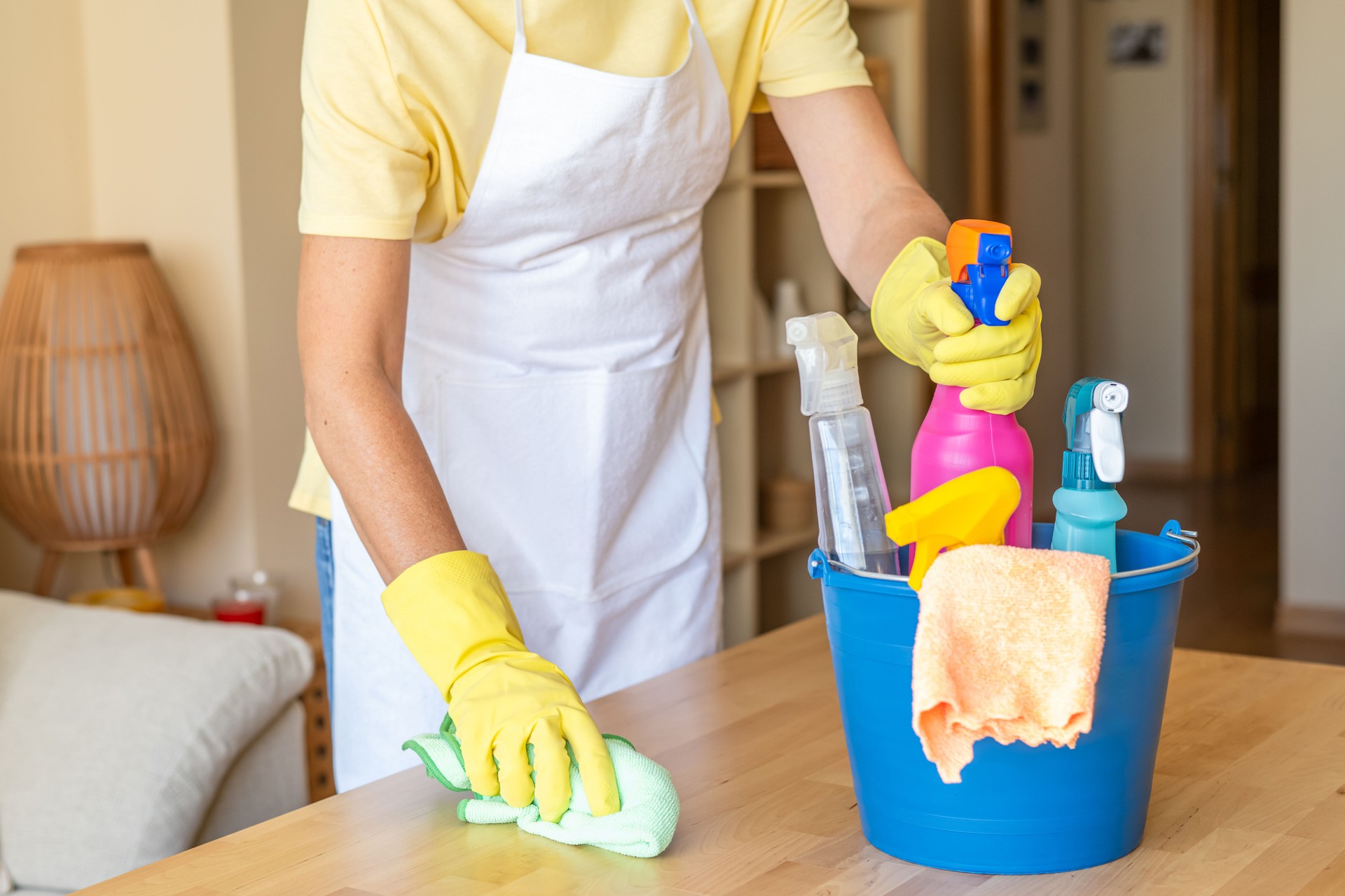Professional Cleaning Service Showing Woman With Gloves Wiping Table With Various Disinfection And Cleaning Products.Home Cleaning Concept