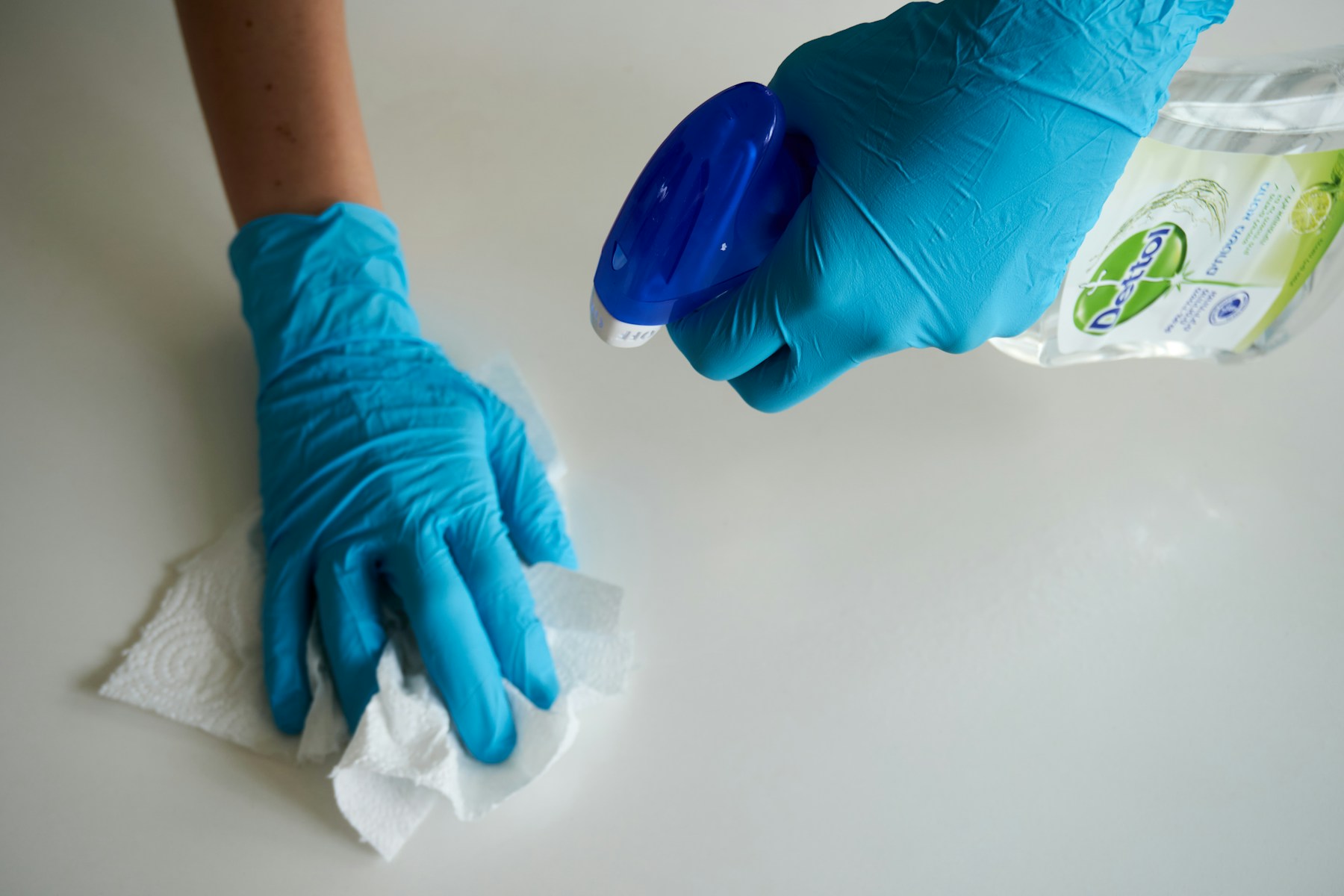 Deep cleaning Chicago: wiping a kitchen surface with gloves and spray cleaner